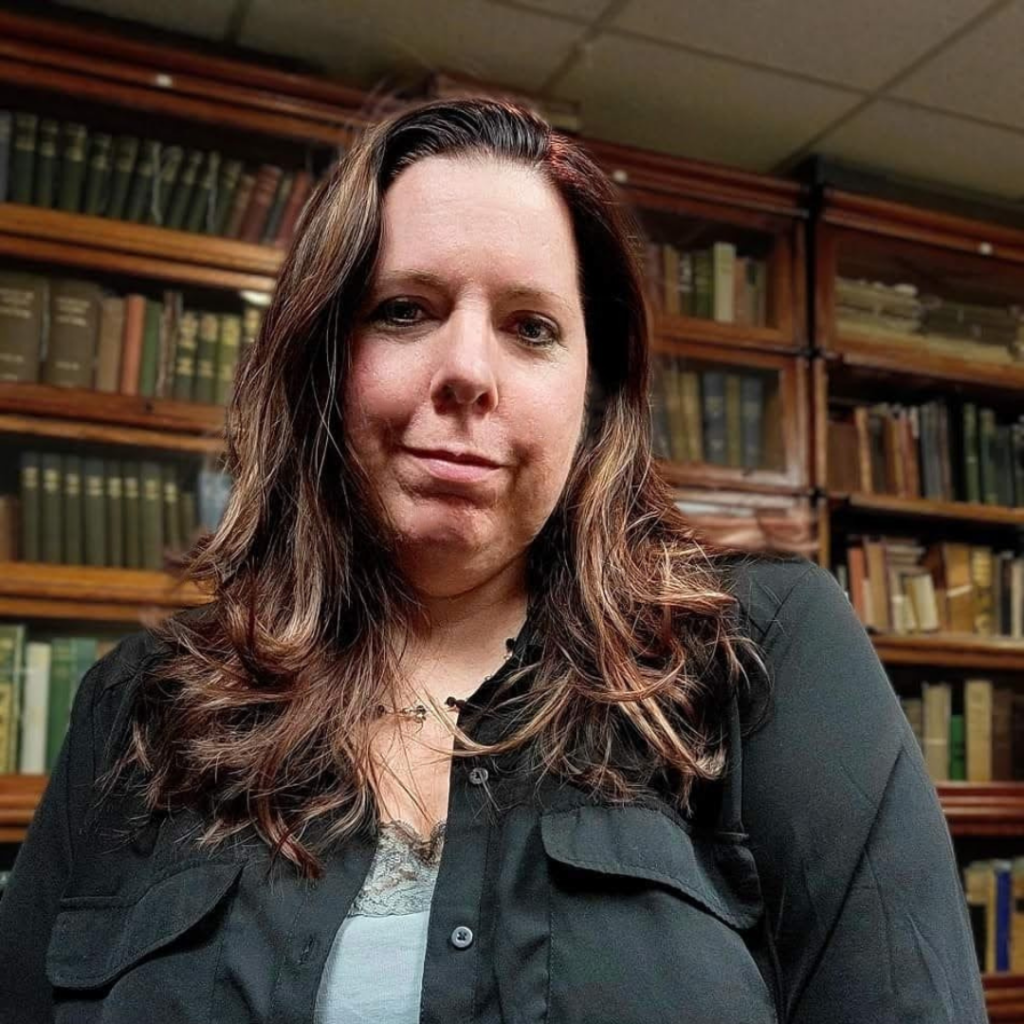Person seated in front of books on shelves
